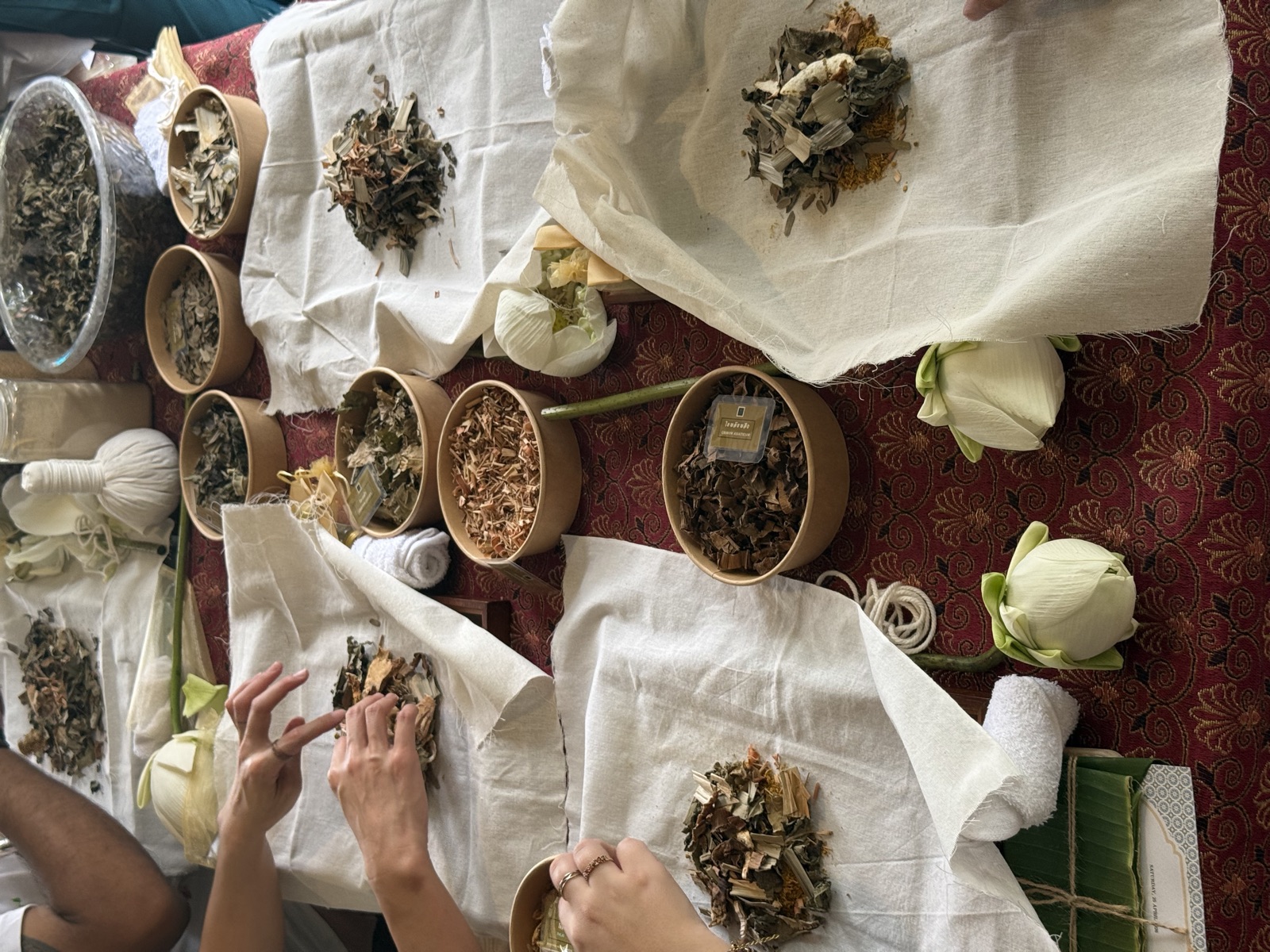 Participants blending dried herbs for compress balls